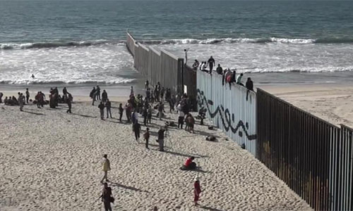 migrantes ante la valla fronteriza